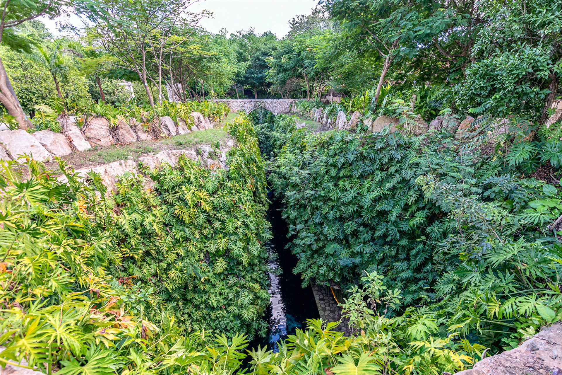 Der Kanal zwischen Cenote Carlota und Cenote Azul Maya mit Brücke und Wasserfall